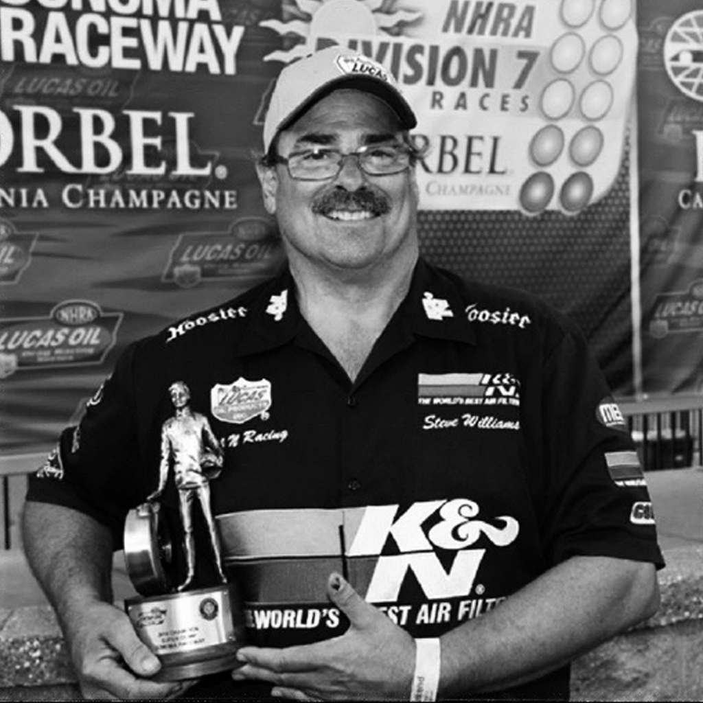 Steve Williams holding an NHRA trophy